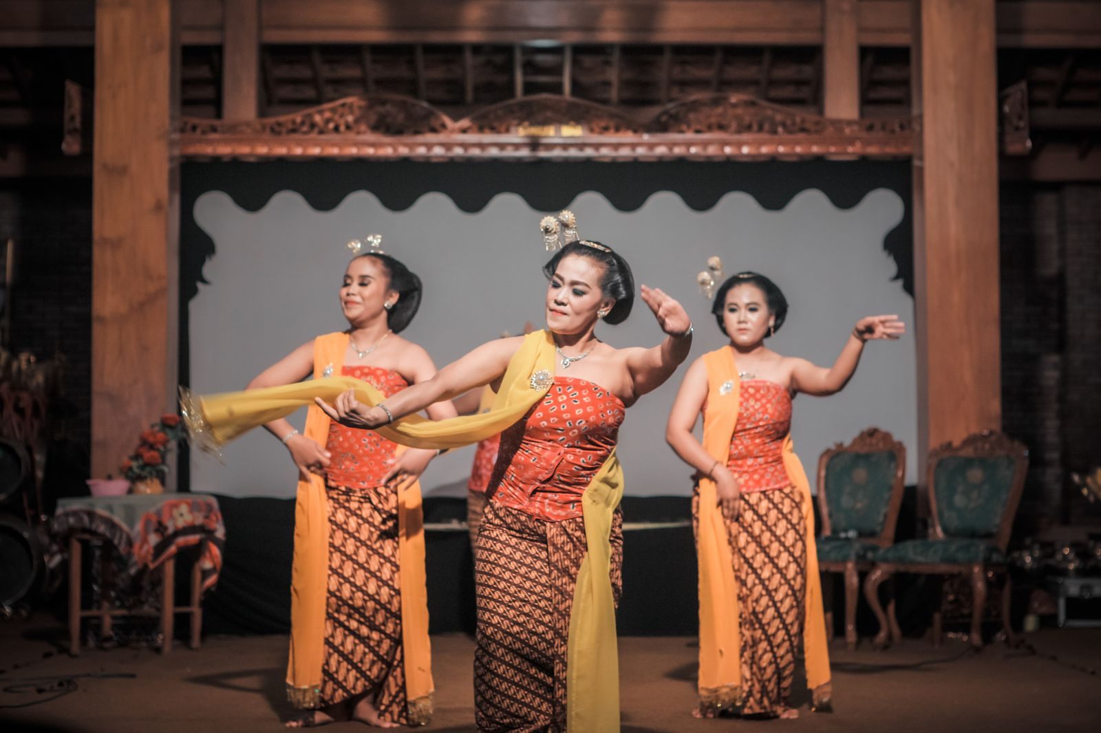 Three dancers in traditional Javanese costume performing on a stage, the kind of performance cultural cruises seek out