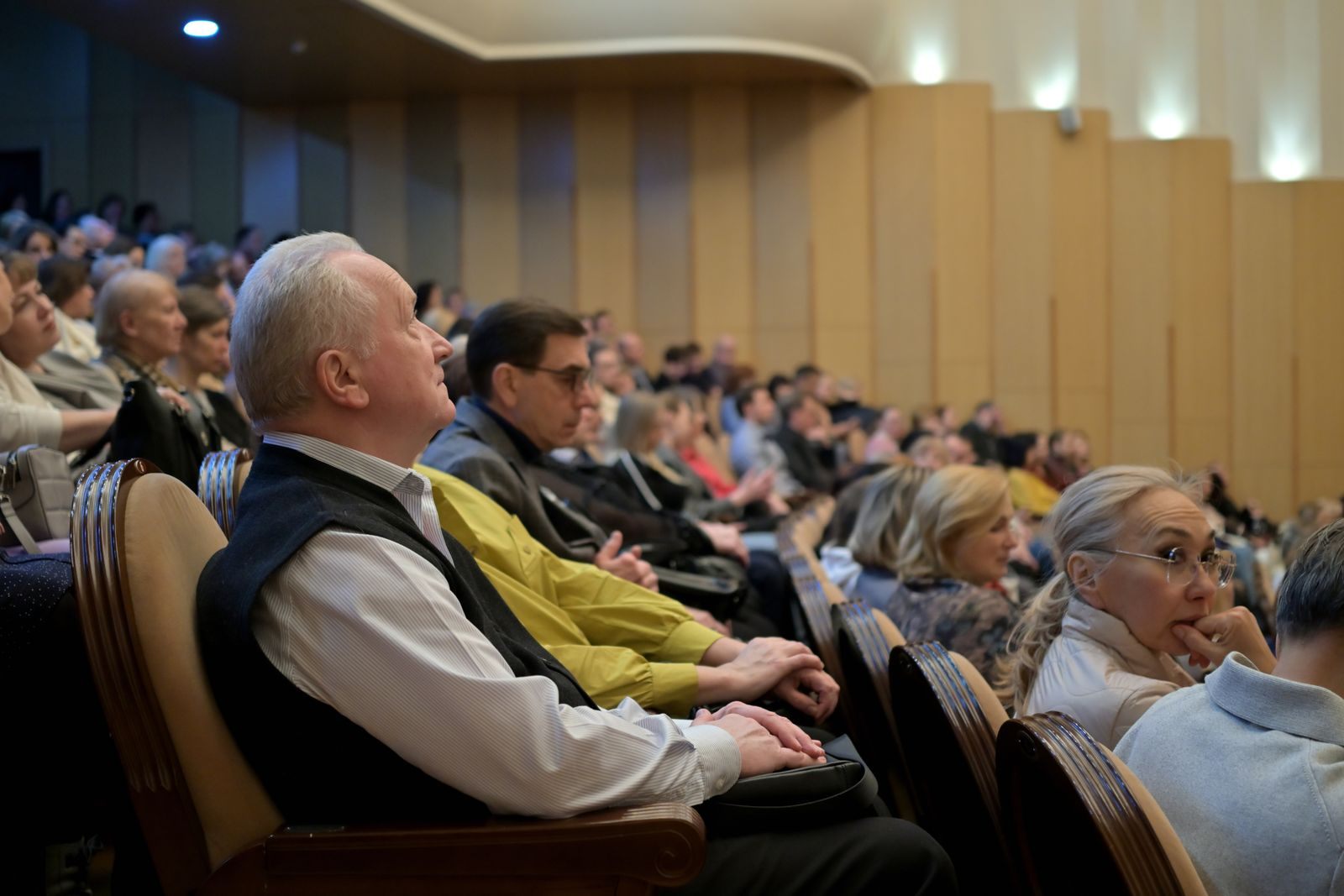 Audience listening closely during a talk in an auditorium
