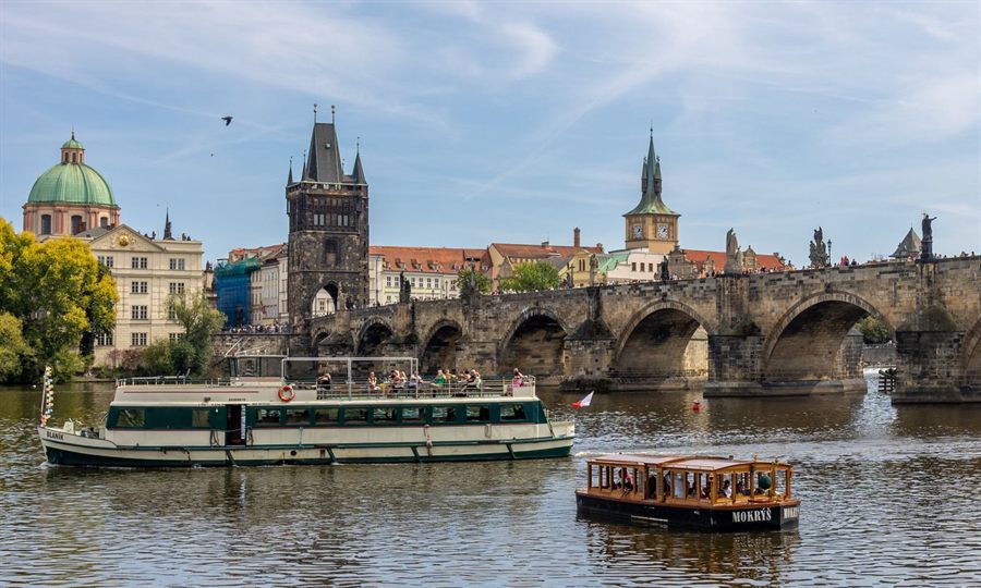 Riverboat on the Vltava passing the Charles Bridge and towers of Prague